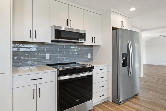 a kitchen with stainless steel appliances white cabinets and a stove