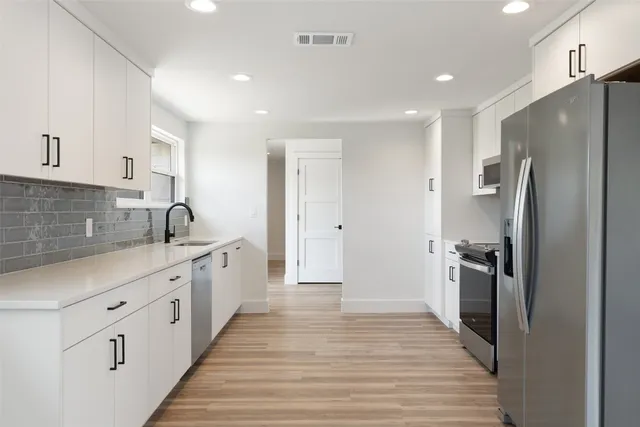 a kitchen with stainless steel appliances a refrigerator sink and cabinets