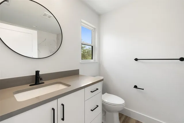 a bathroom with a sink a toilet and a mirror