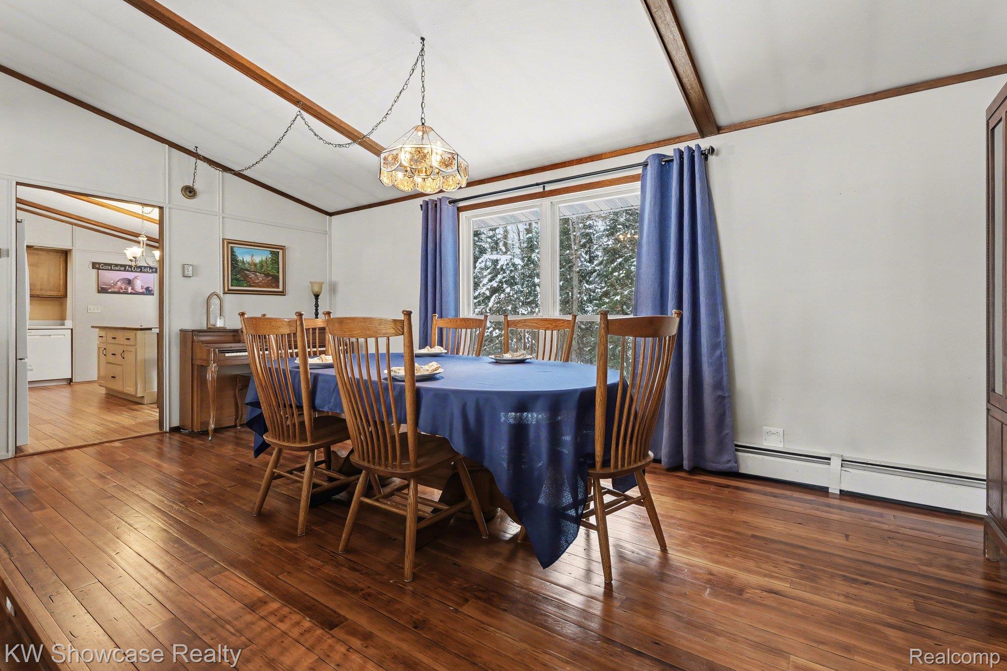 1951 East Kneeland Road Fairview, MI 48621 - Photo 9 of 46 Dining area with dark wood-type flooring, lofted ceiling, baseboard heating, and hanging lights