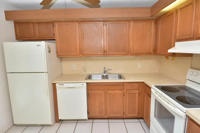 a kitchen with a sink a refrigerator and cabinets