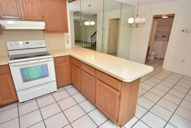 a kitchen with white cabinets a sink a stove and a refrigerator