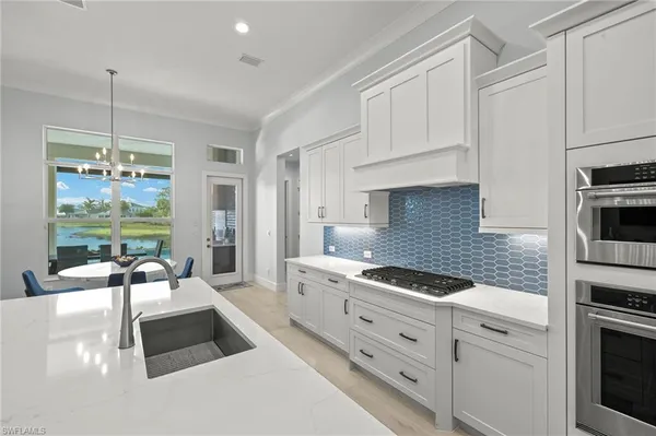 a kitchen with granite countertop white cabinets and white appliances