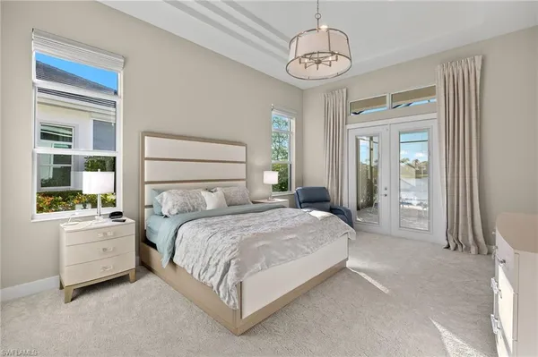 a bedroom with a large bed and a chandelier