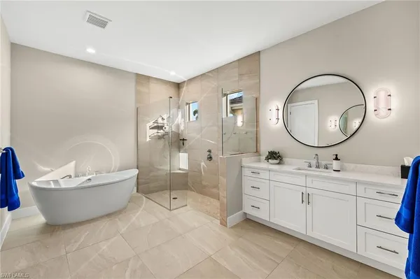 a spacious bathroom with a bathtub shower and a mirror