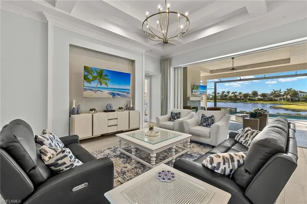 a living room with furniture a chandelier and a flat screen tv