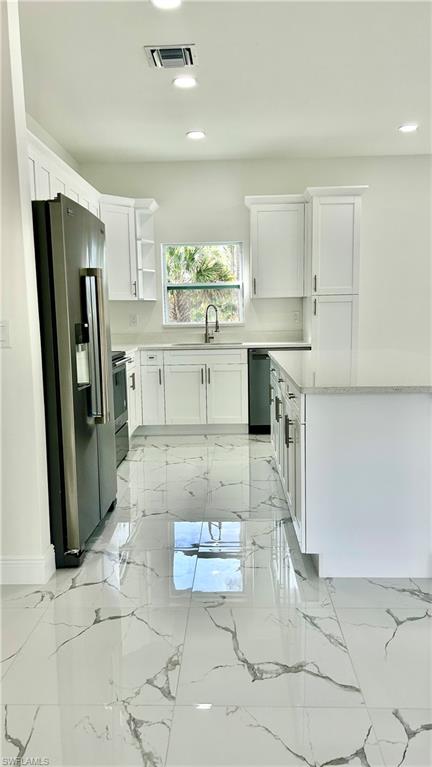 4341 64th Avenue Northeast Naples, FL 34120 - Photo 5 of 9 a kitchen with stainless steel appliances cabinets a sink and a counter top space