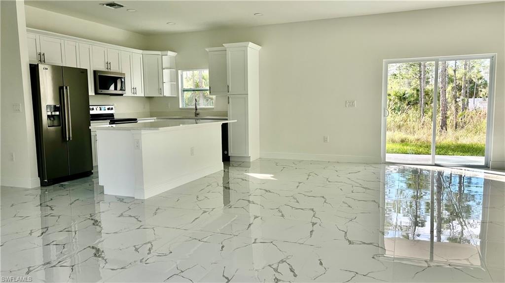4341 64th Avenue Northeast Naples, FL 34120 - Photo 6 of 9 a kitchen with a stove a refrigerator and a sink