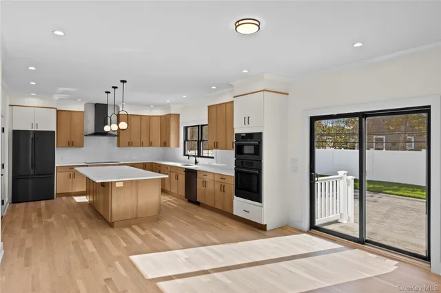 a large kitchen with stainless steel appliances kitchen island granite countertop a refrigerator and a stove top oven