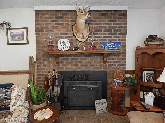 4036 Flat Shoals Road Germanton, NC 27019 - Photo 3 of 16 Living Room. Masonry fireplace with wood stove insert.