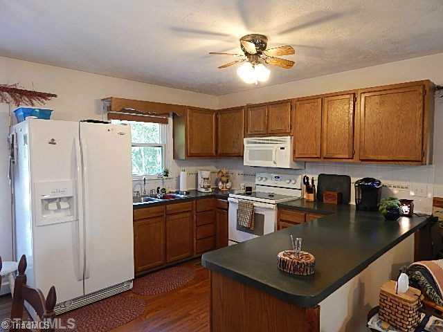 4036 Flat Shoals Road Germanton, NC 27019 - Photo 4 of 16 Kitchen. Convenient kitchen with smooth top range and microwave. The kitchen has wood flooring.