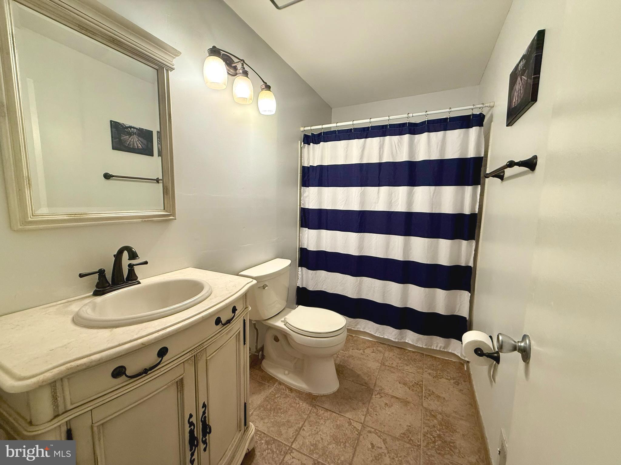 12 Juniper Way Hamilton, NJ 08619 - Photo 12 of 18 a bathroom with a sink a toilet a mirror and shower curtain