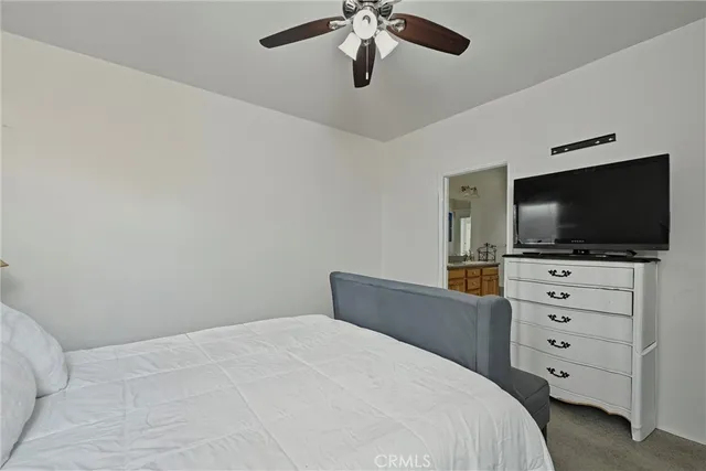 a bedroom with a bed and a flat tv screen on dresser