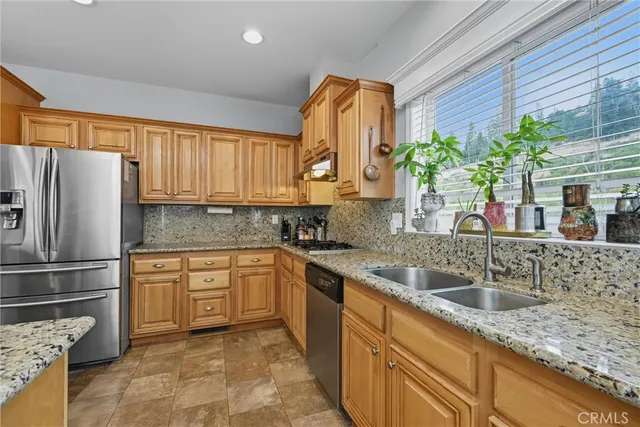 a kitchen with granite countertop a sink stainless steel appliances and cabinets