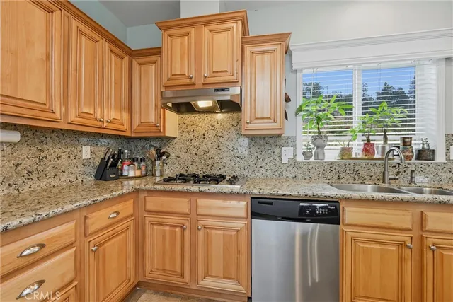 a kitchen with stainless steel appliances granite countertop a sink a stove and a refrigerator