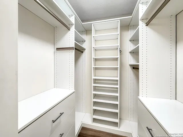 a view of walk in closet with empty racks