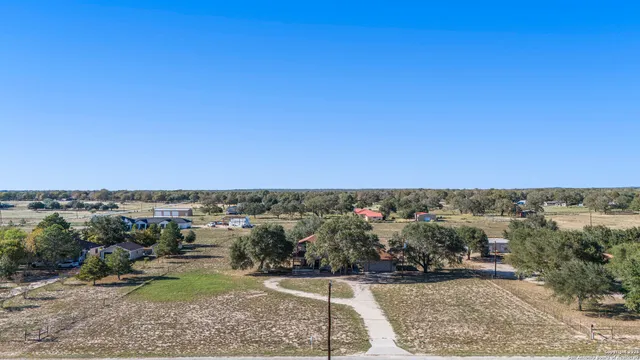 an aerial view of a house with a yard and trees