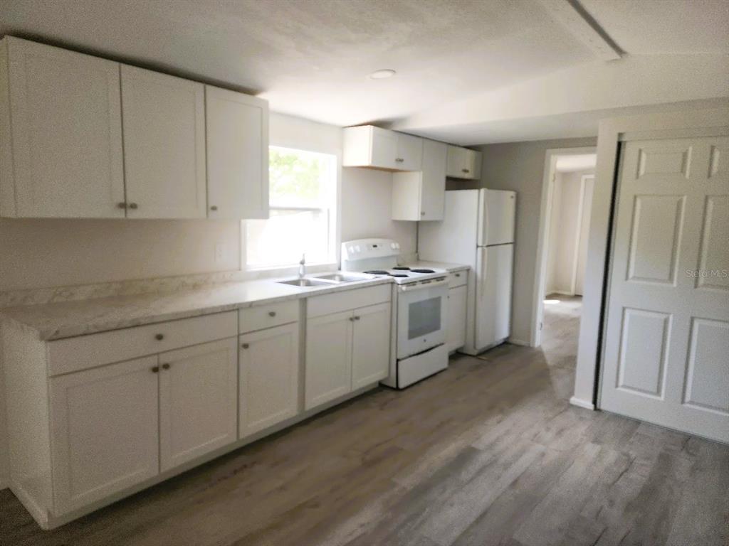 3114 Holly Hill Cutoff Road Davenport, FL 33837 - Photo 3 of 12 a kitchen with stainless steel appliances a refrigerator sink and cabinets