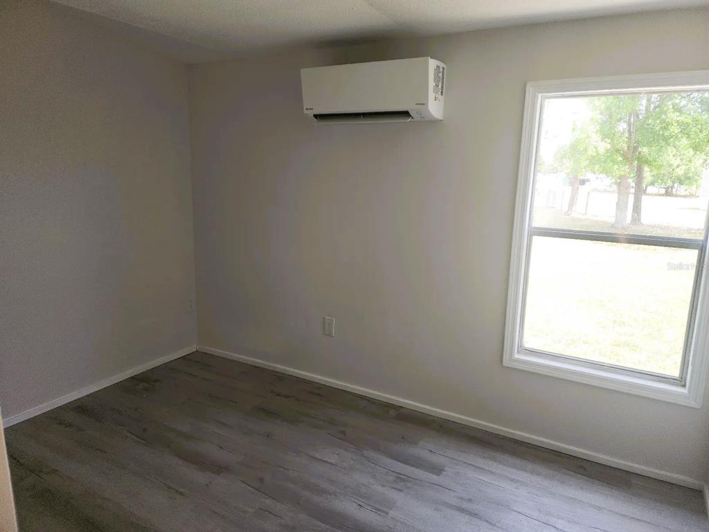 3114 Holly Hill Cutoff Road Davenport, FL 33837 - Photo 6 of 12 an empty room with wooden floor and windows