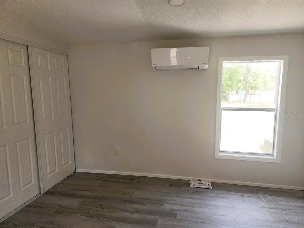 3114 Holly Hill Cutoff Road Davenport, FL 33837 - Photo 10 of 12 an empty room with wooden floor and windows