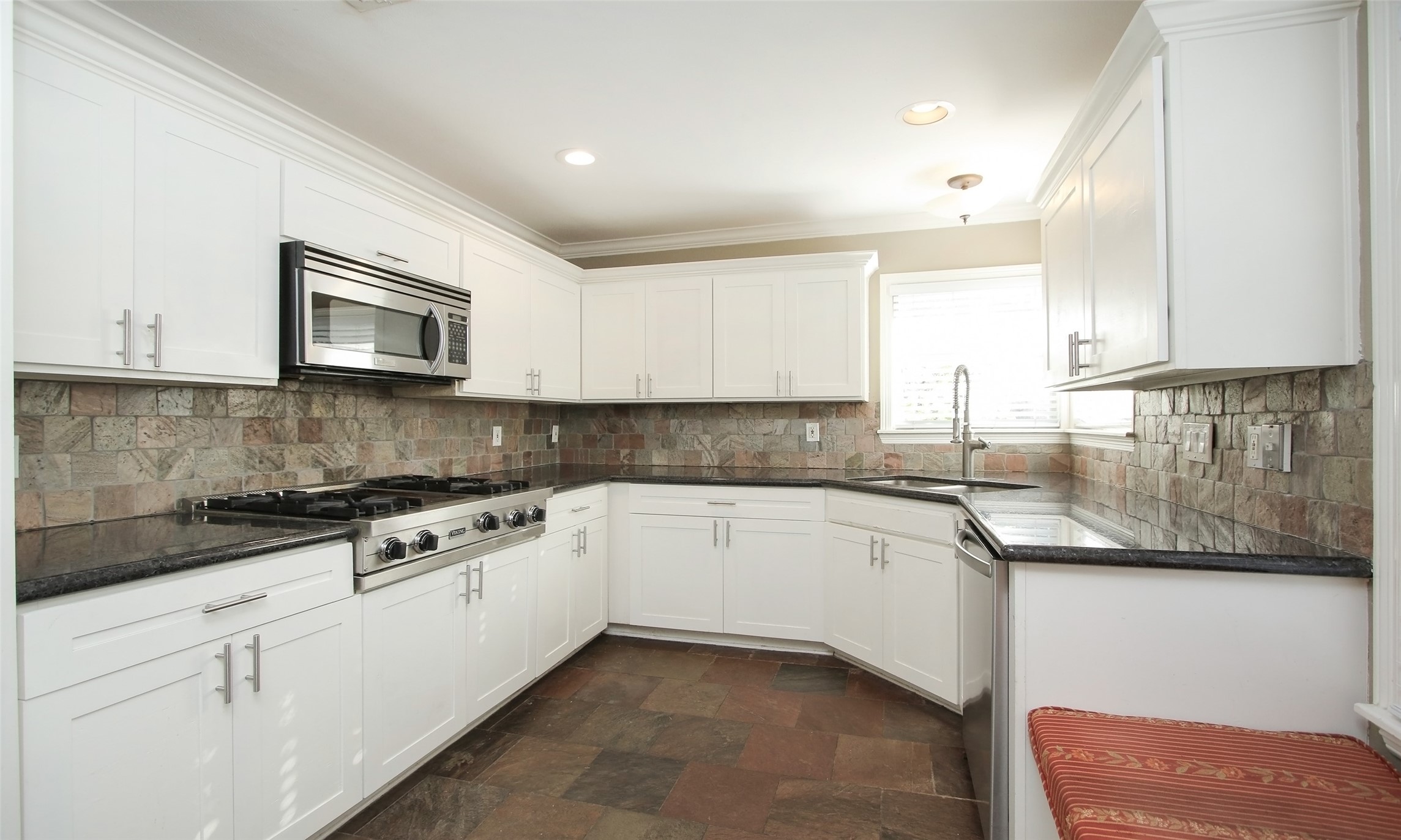 4809 Saxon Street Bellaire, TX 77401 - Photo 13 of 34 a kitchen with granite countertop a sink a stove and cabinets