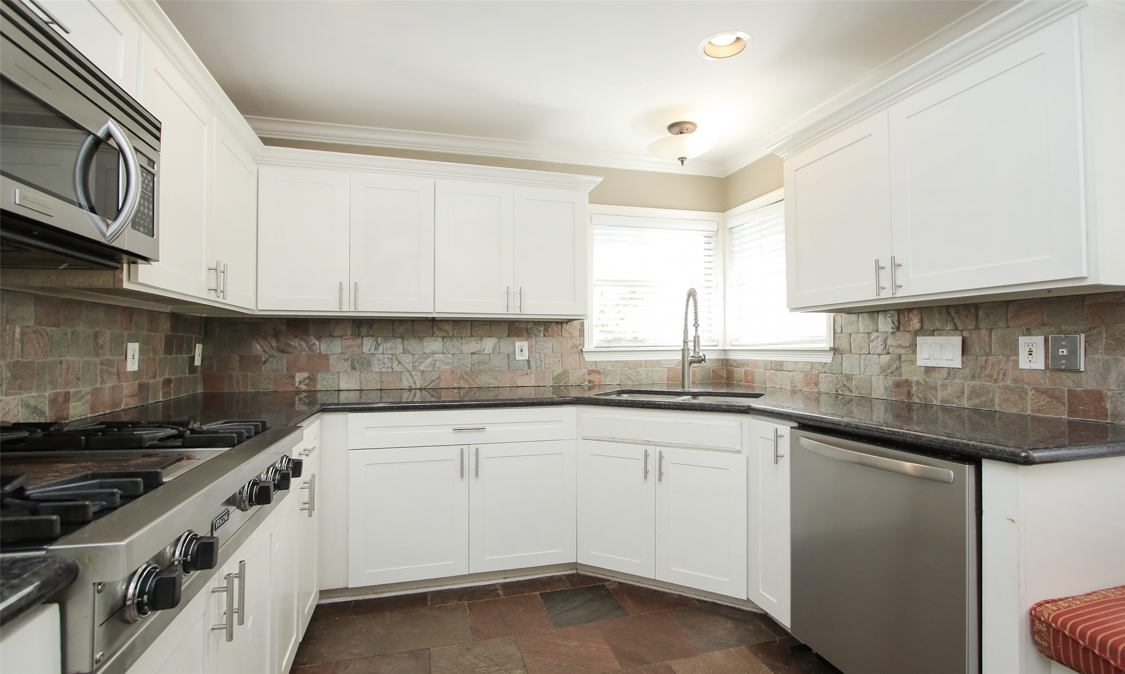 4809 Saxon Street Bellaire, TX 77401 - Photo 14 of 34 a kitchen with granite countertop white cabinets and a sink