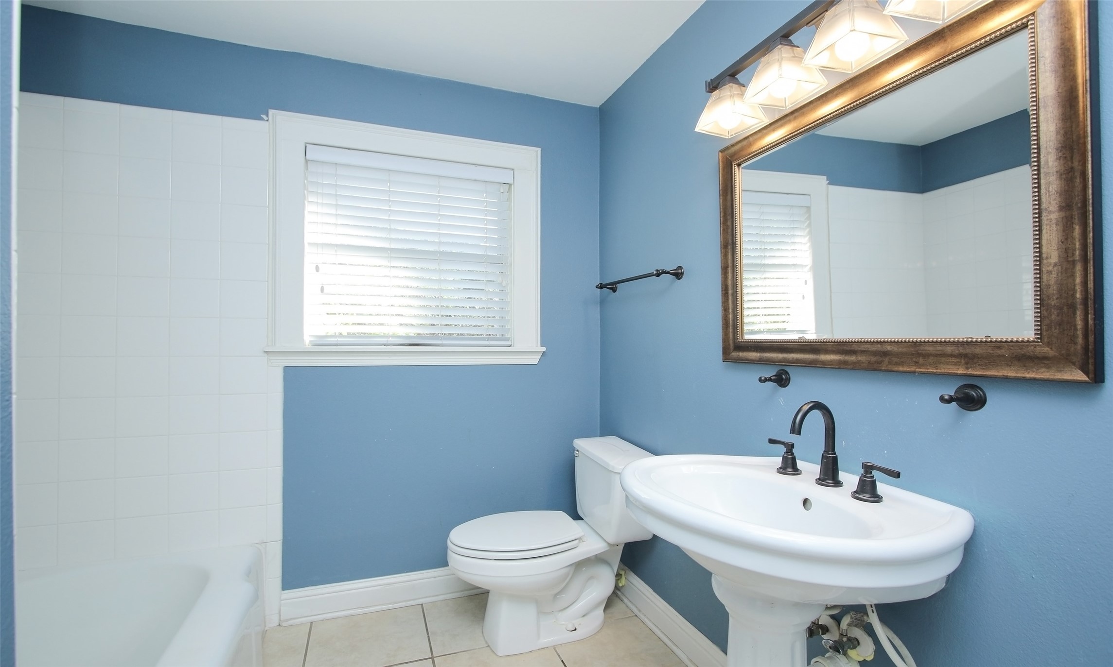 4809 Saxon Street Bellaire, TX 77401 - Photo 28 of 34 a bathroom with a sink a mirror and a toilet