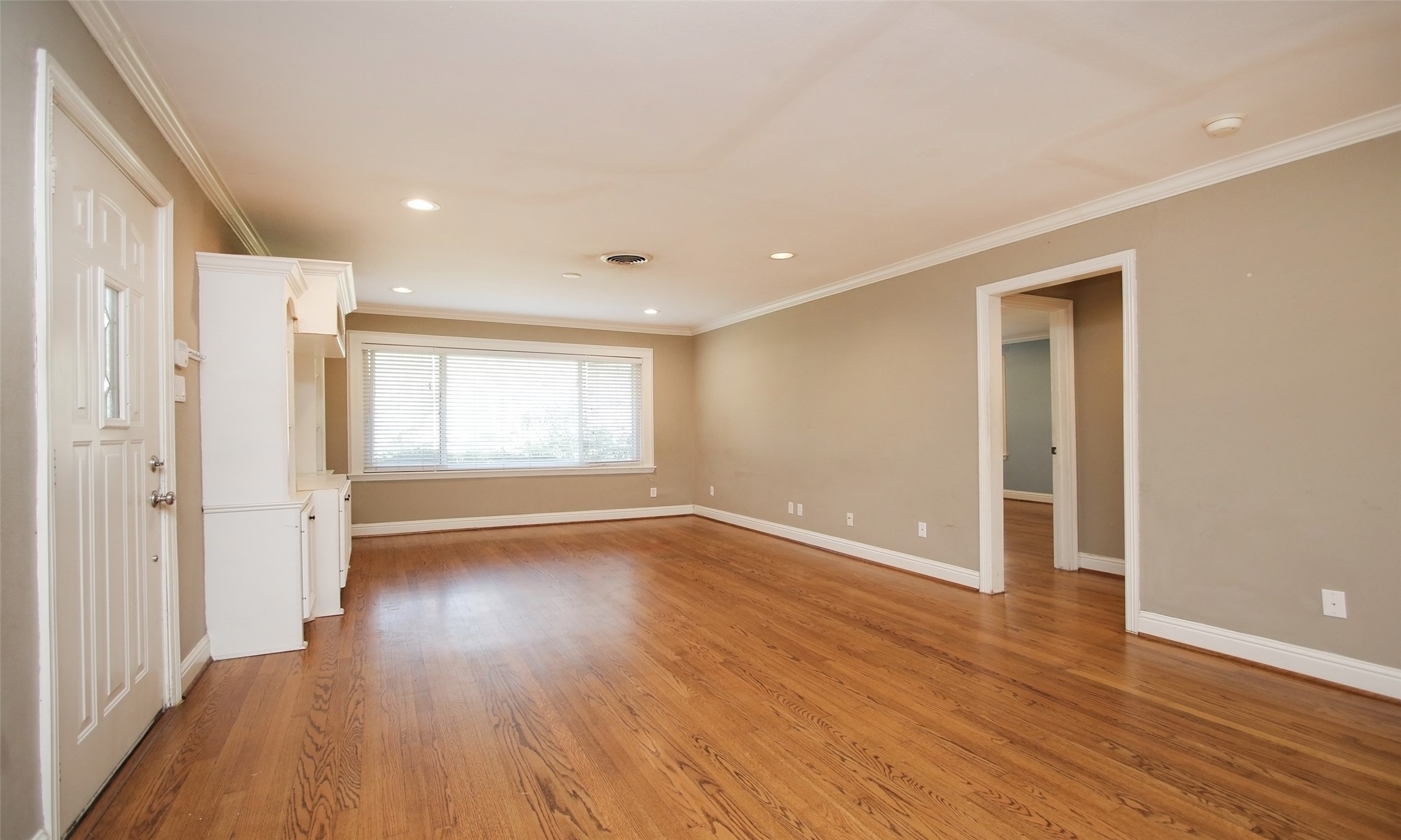 4809 Saxon Street Bellaire, TX 77401 - Photo 5 of 34 a view of an empty room with wooden floor and a window