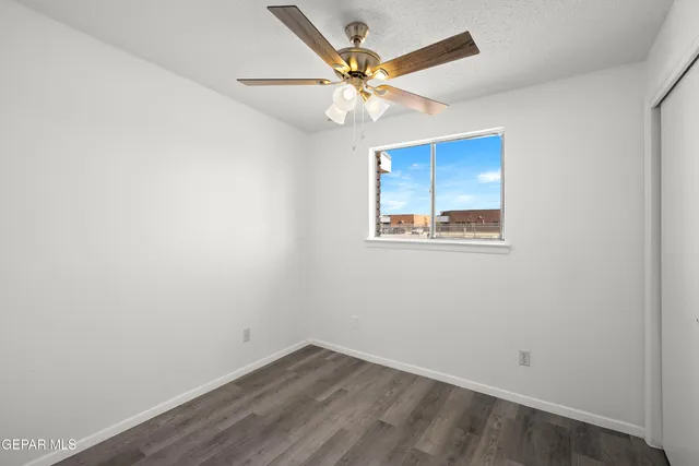 an empty room with a ceiling fan and a window