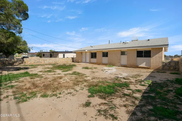a view of a yard with table and chairs under an umbrella