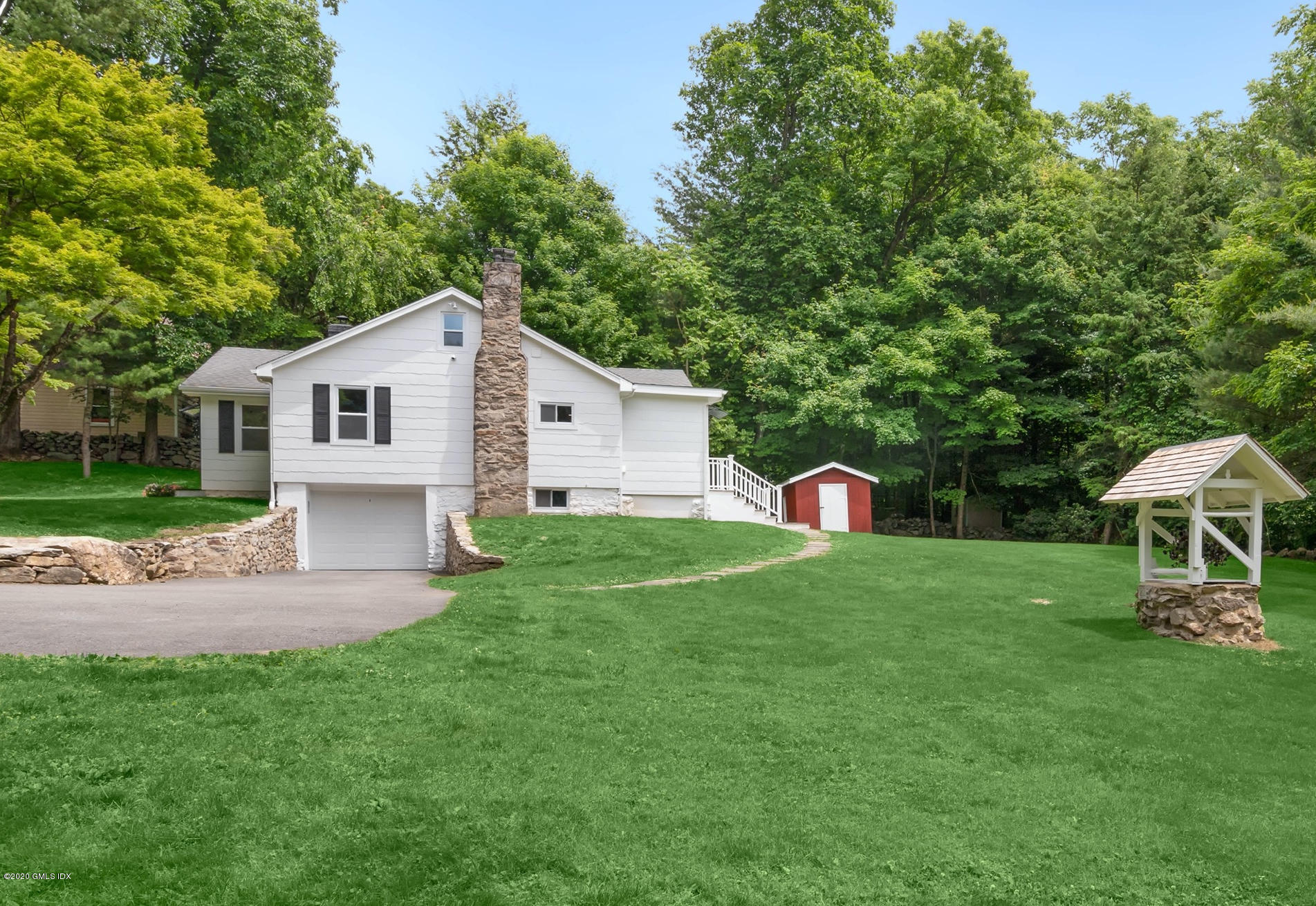 142 Old Mill Road Greenwich, CT 06831 - Photo 3 of 23 a front view of a house with a yard and trees