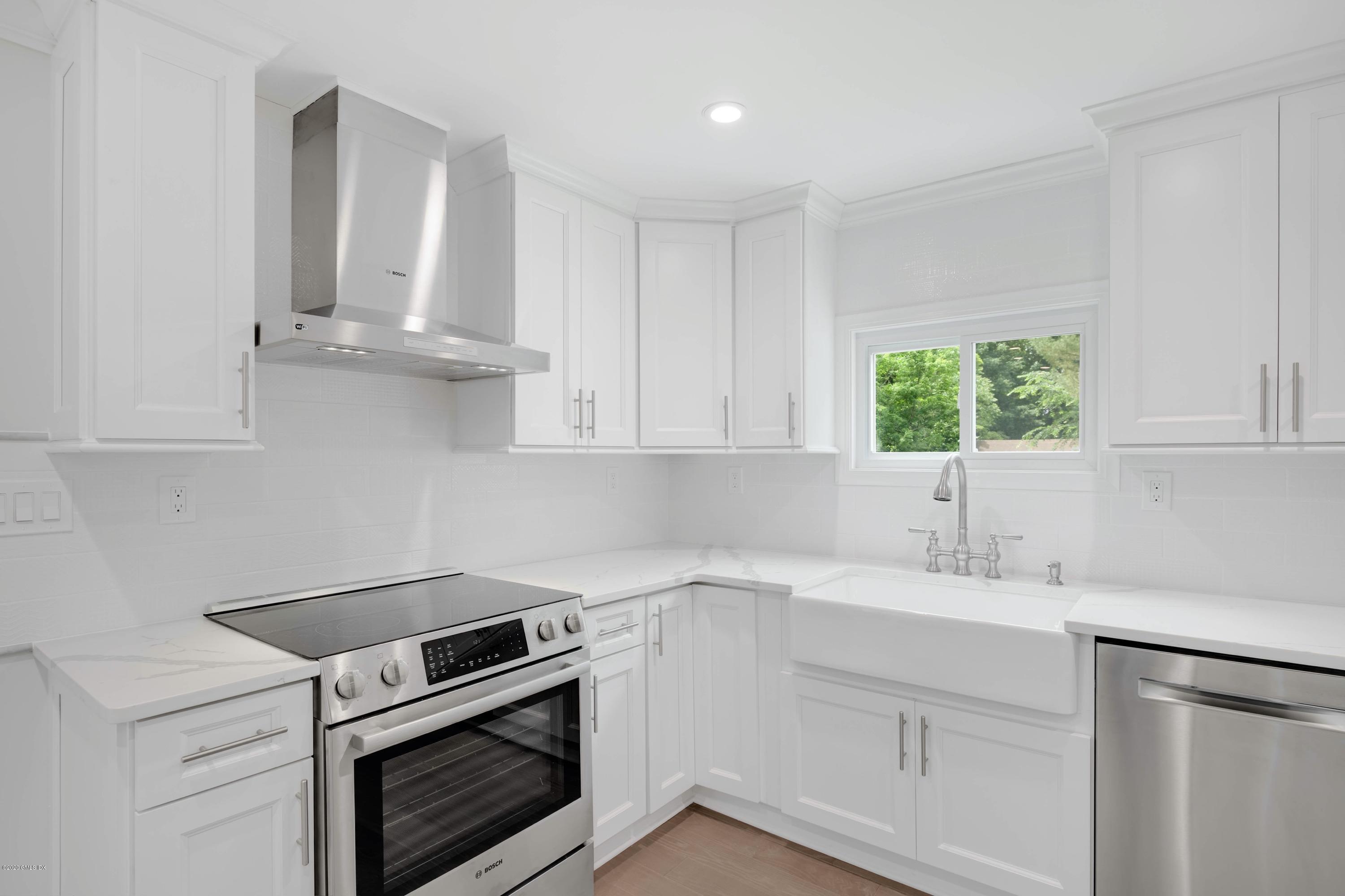 142 Old Mill Road Greenwich, CT 06831 - Photo 7 of 23 a kitchen with white cabinets appliances and a sink