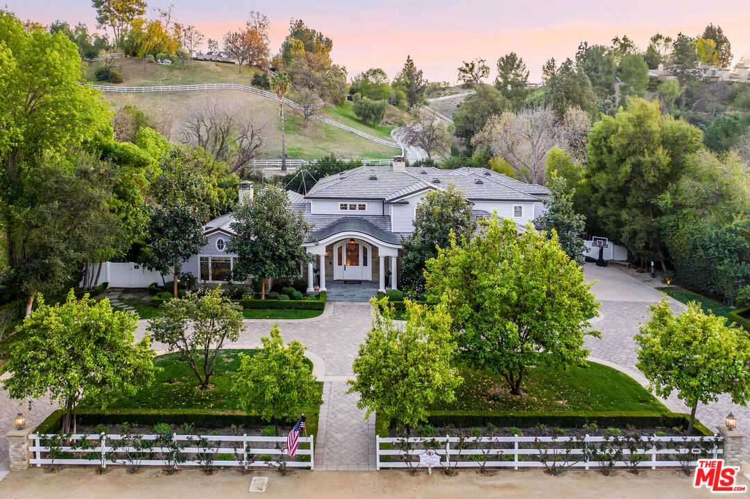 an aerial view of a house with a garden and lake view