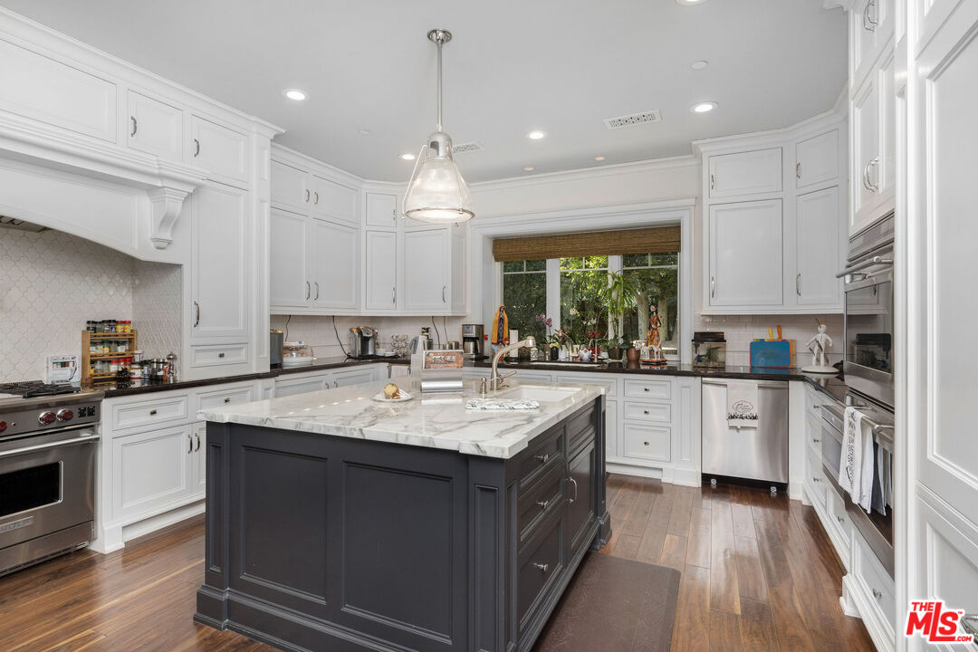 23924 Long Valley Road Hidden Hills, CA 91302 - Photo 13 of 46 a kitchen with a sink window and cabinets