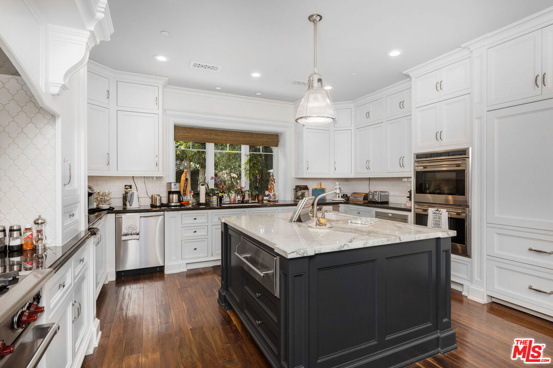 23924 Long Valley Road Hidden Hills, CA 91302 - Photo 15 of 46 a kitchen with a sink window and cabinets