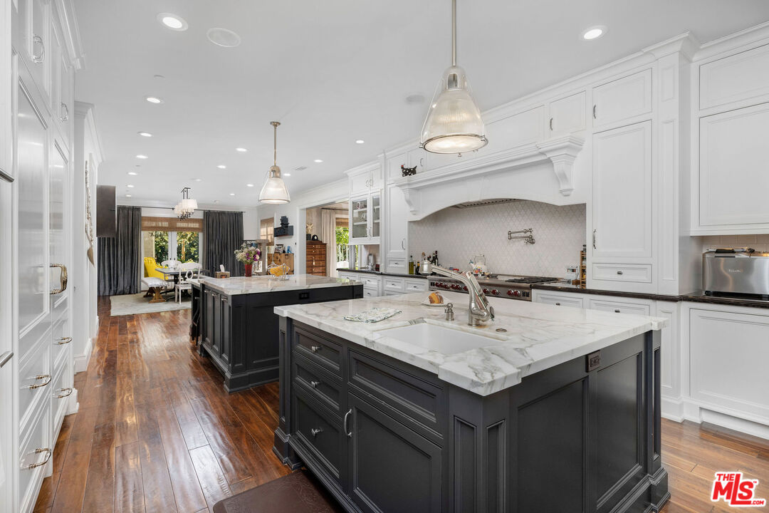 23924 Long Valley Road Hidden Hills, CA 91302 - Photo 16 of 46 a kitchen with stainless steel appliances granite countertop a sink a stove and a wooden floors