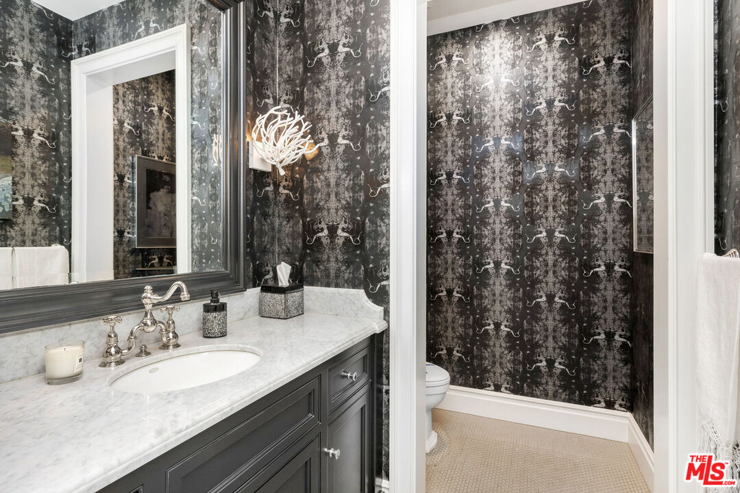 23924 Long Valley Road Hidden Hills, CA 91302 - Photo 27 of 46 a bathroom with a granite countertop sink a mirror and shower