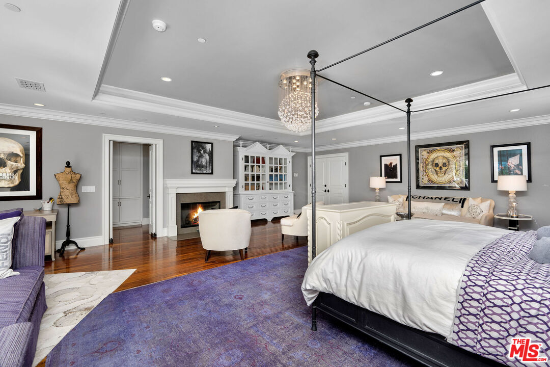 23924 Long Valley Road Hidden Hills, CA 91302 - Photo 33 of 46 a spacious bedroom with a large bed and a chandelier