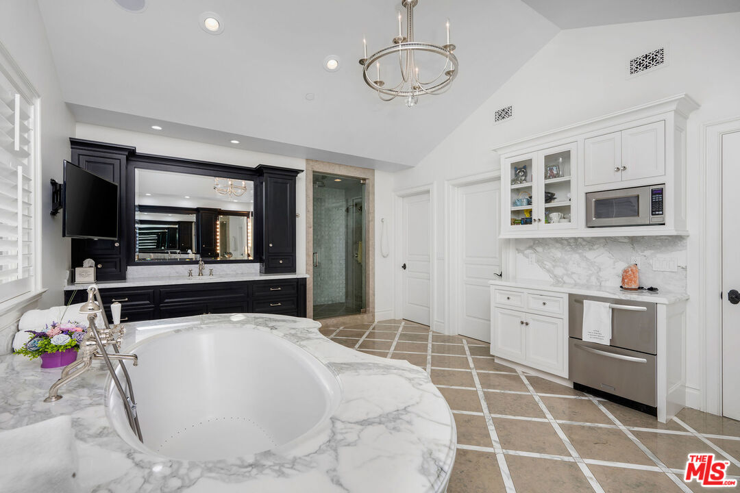 23924 Long Valley Road Hidden Hills, CA 91302 - Photo 37 of 46 a large white kitchen with stainless steel appliances granite countertop a stove and a sink
