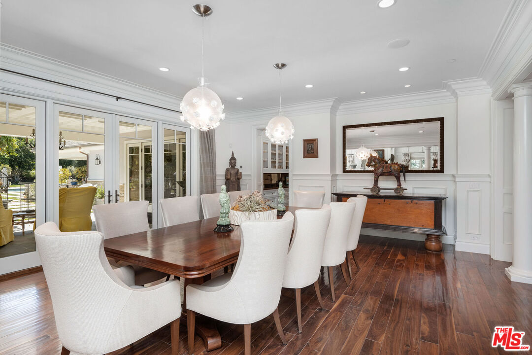 23924 Long Valley Road Hidden Hills, CA 91302 - Photo 10 of 46 a dining room with wooden floor a chandelier a glass table and chairs