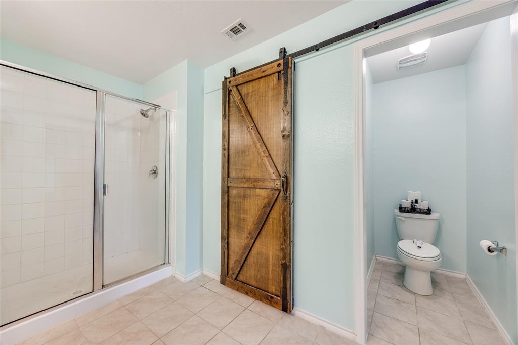 1011 Riverstone Trail Princeton, TX 75407 - Photo 14 of 26 a bathroom with a granite countertop sink a toilet and a shower