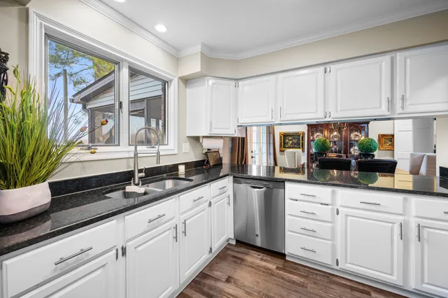 a kitchen with granite countertop white cabinets and white appliances