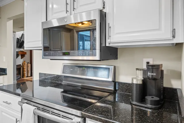 a kitchen with granite countertop a stove and cabinets
