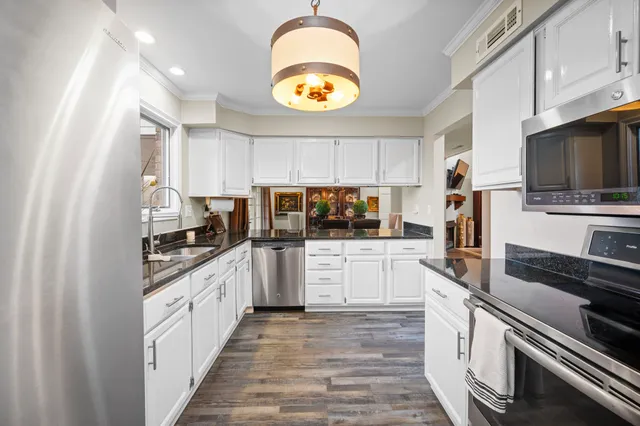a large kitchen with stainless steel appliances granite countertop a stove and a sink