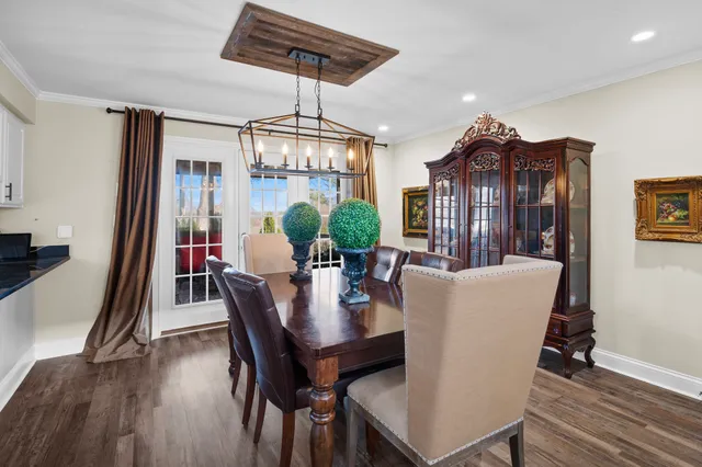 a view of a dining room with furniture wooden floor and chandelier