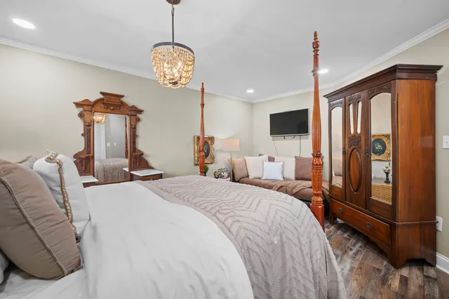 a bedroom with bed and a chandelier