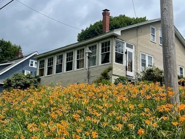 a front view of a house with a garden