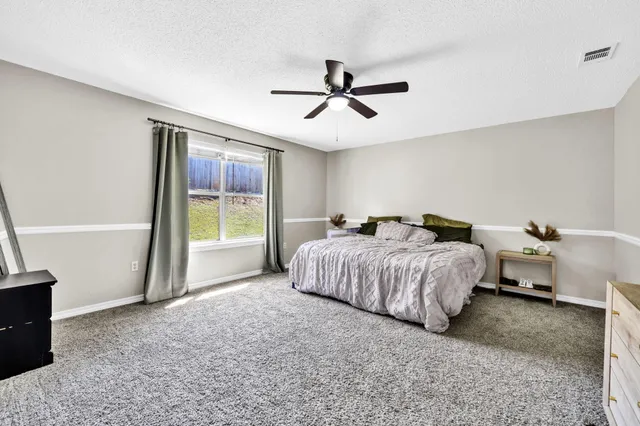 a spacious bedroom with a bed and a window