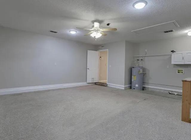 an empty room with a ceiling fan and window