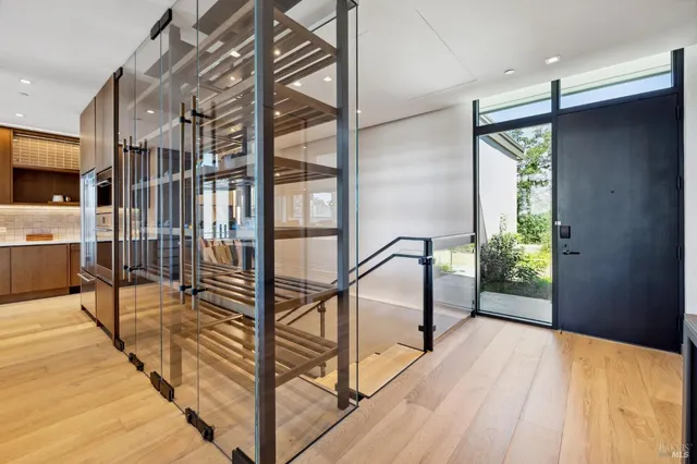 a living room with furniture potted plant and kitchen view